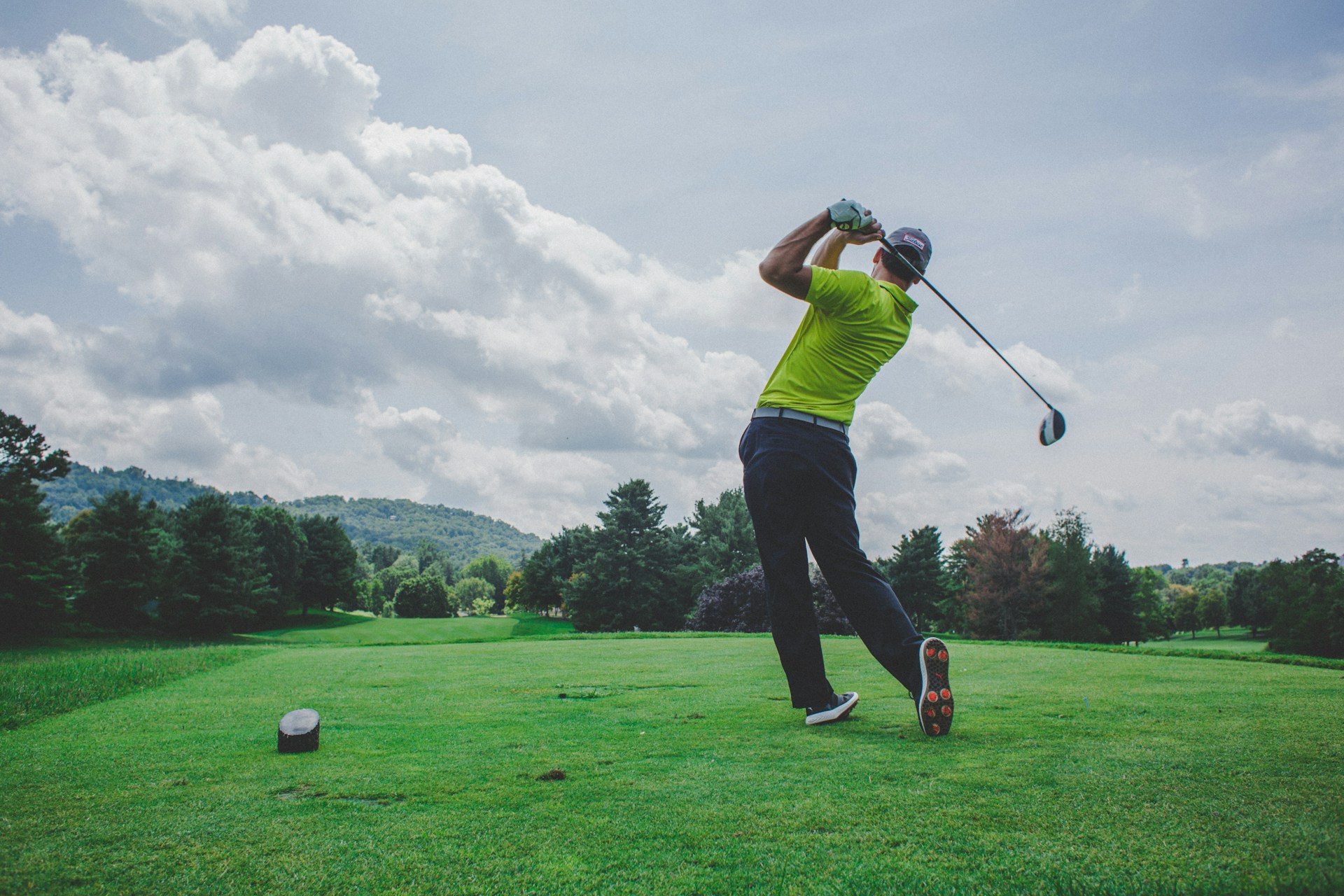 Golfer mid-swing on a golf course
